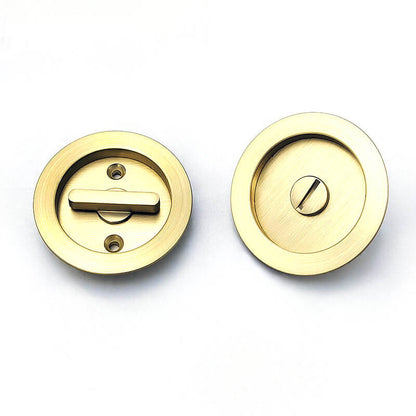 The lock plates of two golden circular pocket door locks