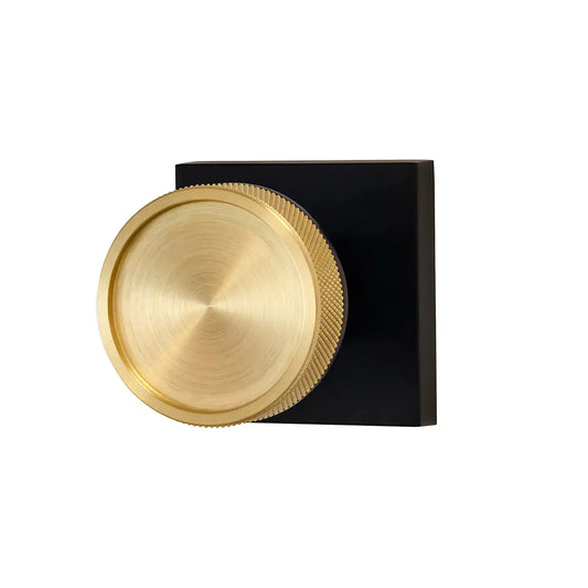 Wall-mounted light fixture with gold circular design on a black base