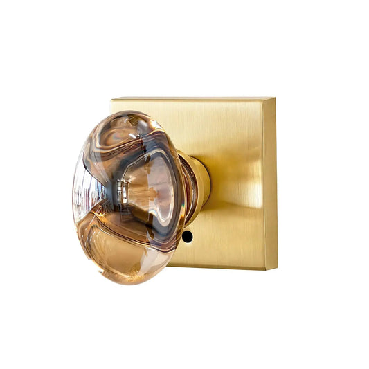 Gold door handle with glass knob on a white background